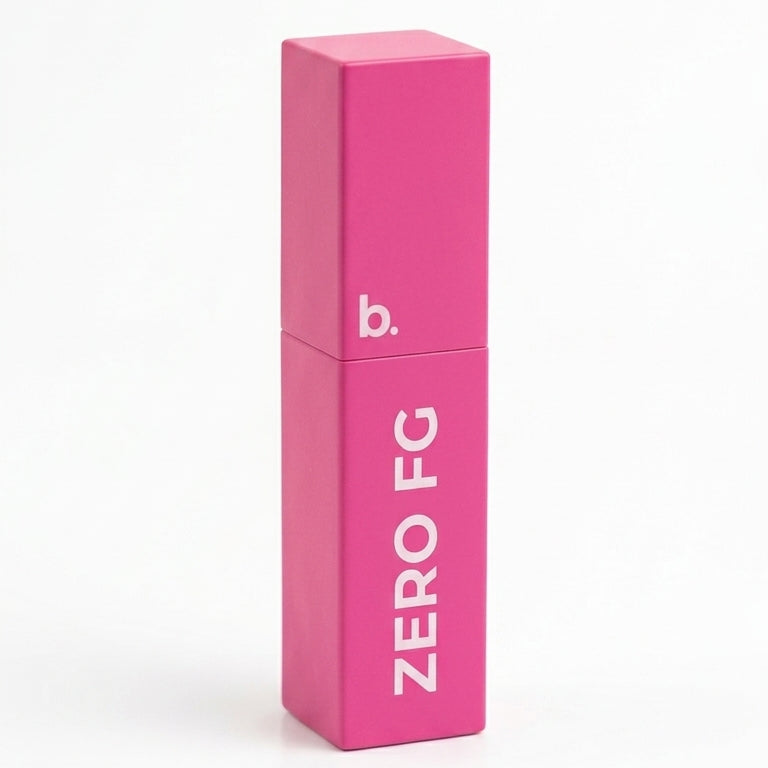 A bright pink rectangular cosmetic tube with a matching cap, standing upright on a white background. The tube features the text 'ZERO FG' in white and a small 'b.